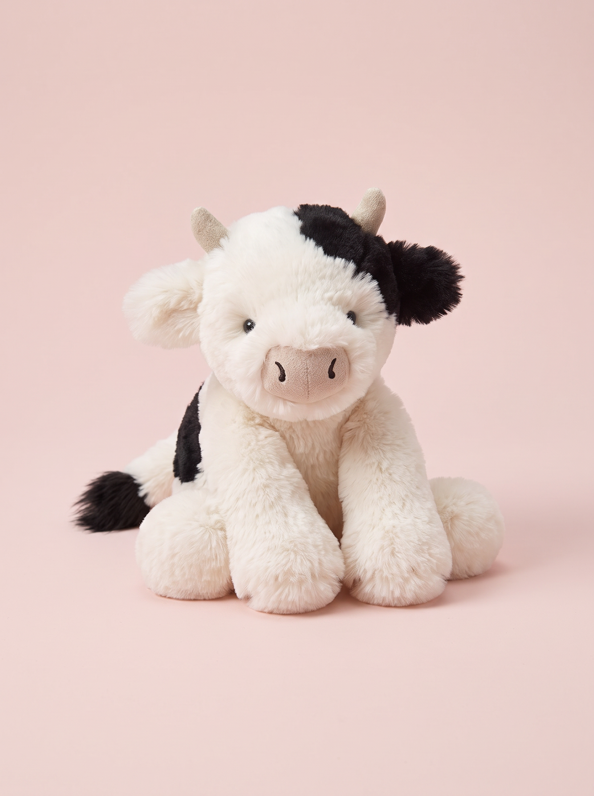 Cow Plush Toy front view on a pink studio background