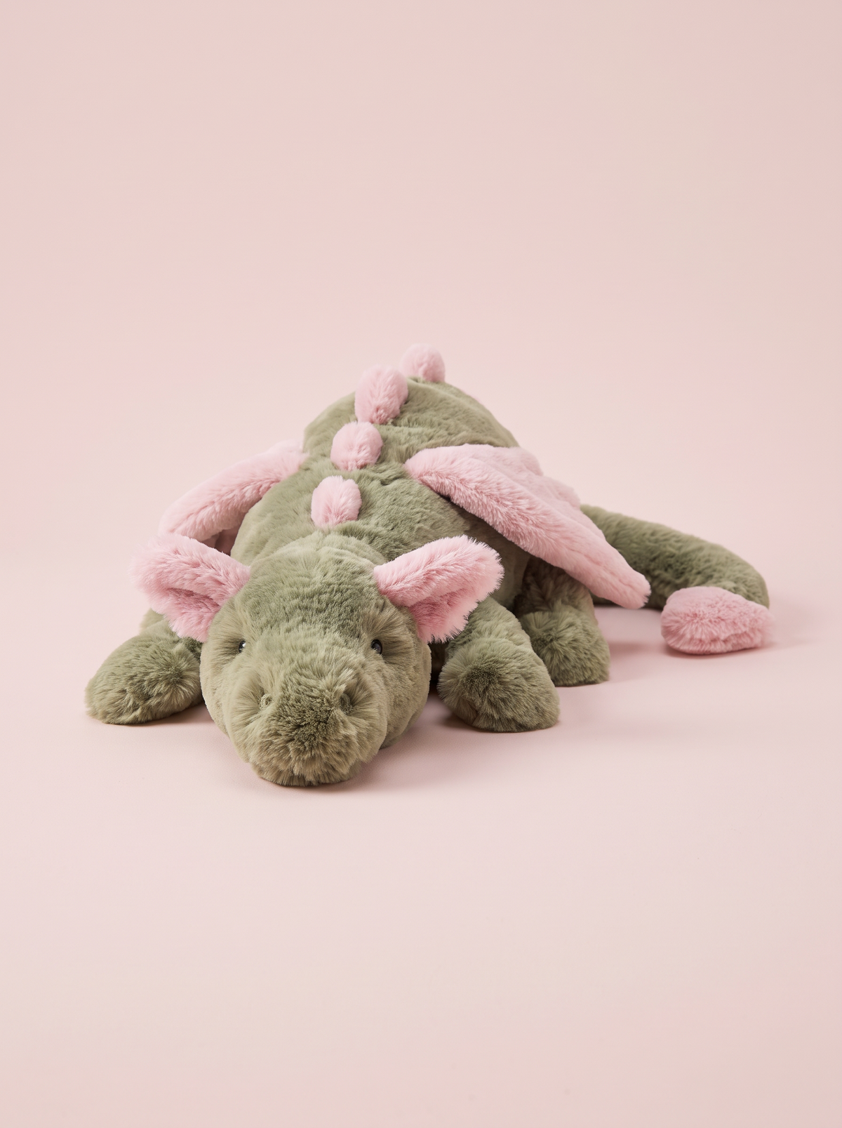 Green and Pink Dragon Plush Toy front view on a pink studio background