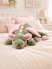 Green and Pink Dragon Plush Toy on a bed in a bright children's bedroom