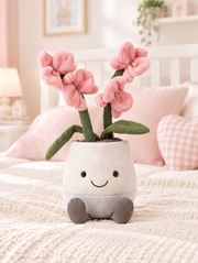 Potted Pink Orchid Plush Toy on a bed in a bright children's bedroom