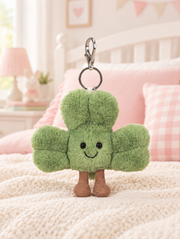 Shamrock Plush Bag Charm on a bed in a bright children's bedroom