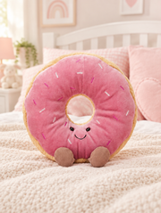 Pink Frosted Doughnut Plush Toy on a bed in a bright children's bedroom