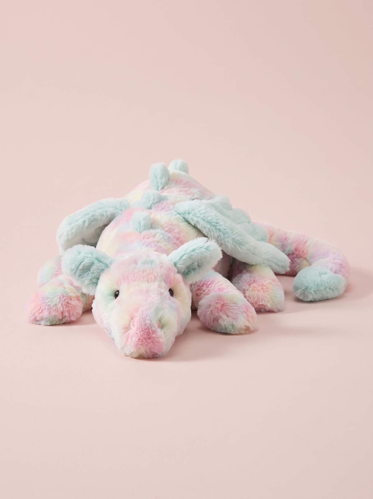 Pastel Rainbow Dragon Plush Toy front view on a pink studio background