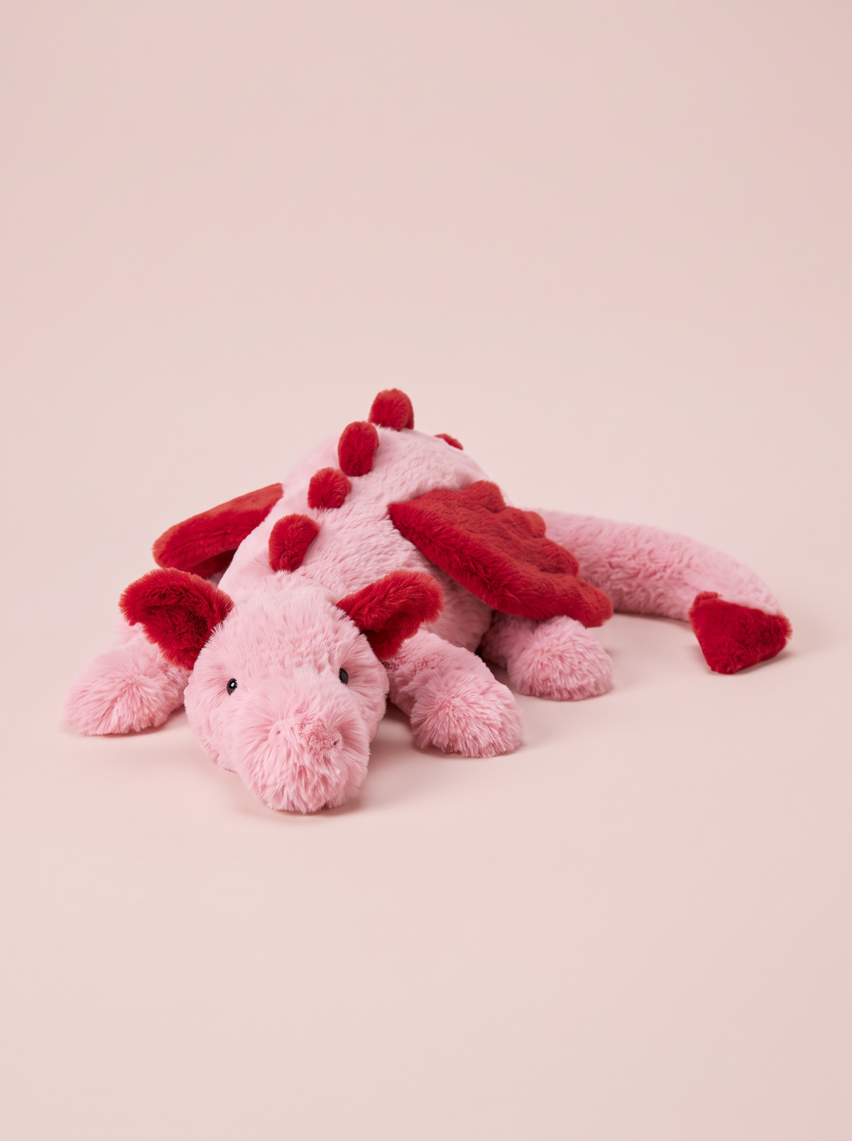 Pink and Red Dragon Plush Toy front view on a pink studio background