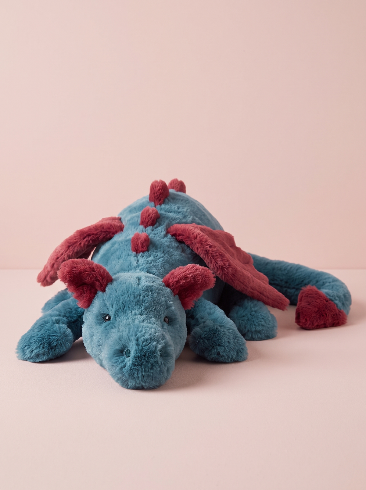 Teal and Red Dragon Plush Toy front view on a pink studio background